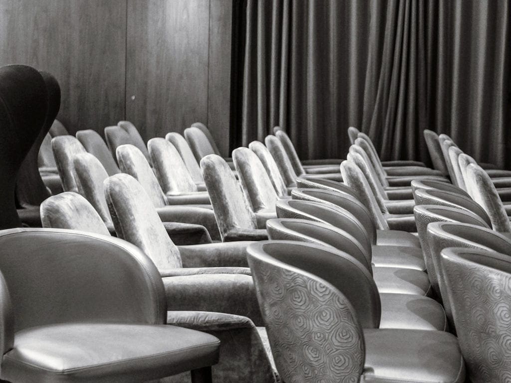 Una foto en blanco y negro muestra sillas vacías de un salón de baile en el barco.