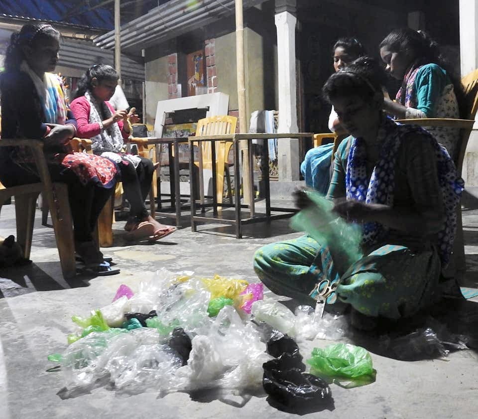 Women cutting plastic bags with scissors.