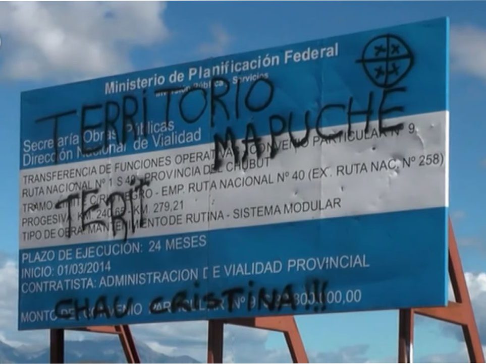 Near the disputed land a government sign in Argentina is spray painted with the message 