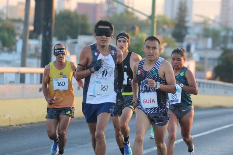 David Juárez runs in a race with the help of a guide