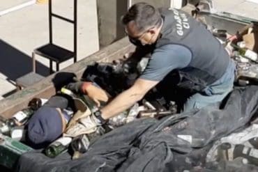 Policía nacional española revisa los contenedores donde se encontraron vivos los cadáveres.
